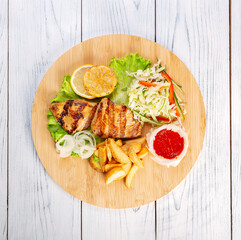 Steak Turkey Grill With Fried Potatoes And Salad On Wooden Board.