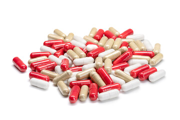 Close-up of a pile of pills or capsules in different colors on isolated white background. Selective Focus.