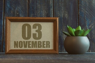 november 3rd. Day 3 of month, date in frame next to succulent on wooden background autumn month, day of the year concept