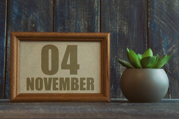 november 4th. Day 4 of month, date in frame next to succulent on wooden background autumn month, day of the year concept