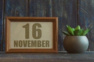 november 16th. Day 16 of month, date in frame next to succulent on wooden background autumn month, day of the year concept