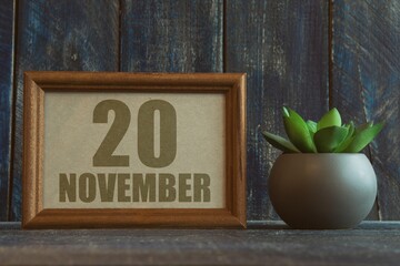 november 20th. Day 20 of month, date in frame next to succulent on wooden background autumn month, day of the year concept