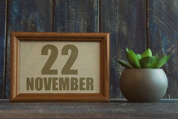 november 22nd. Day 22 of month, date in frame next to succulent on wooden background autumn month, day of the year concept