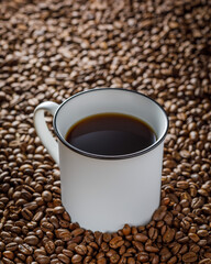 white cup of coffee on the background with coffee beans 