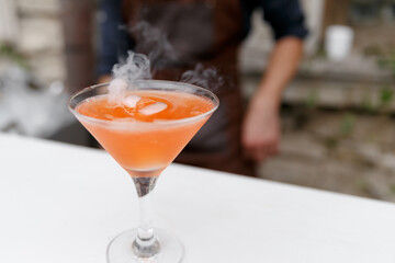 Steaming orange cocktail. Martini glass