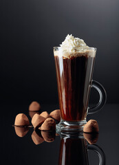 Truffles and glass of hot chocolate with whipped cream.