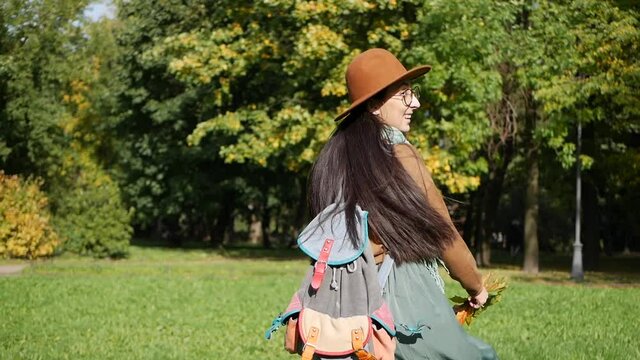 Middle eastern woman enjoying sunny autumn day walking in the park
