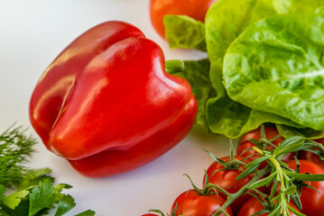 Big red pepper with vegetables on a white table. Proper nutrition. fresh vegetables on a white table.