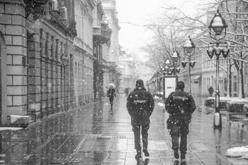 Police patrolling and walking trough empty streets on snowy day in Belgrade,Serbia during police hour due to corona virus covid-19