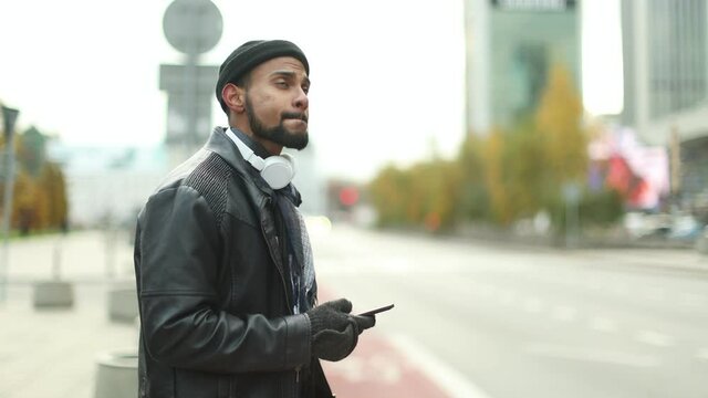 Man in Warsaw using phone and waiting for a taxi 
