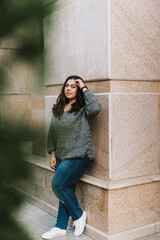 Portrait of a young adult girl on the background of a modern building