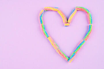 Fototapeta na wymiar Heart shaped gummies on purple background.