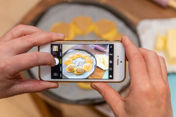 Woman photographing the pastries she makes