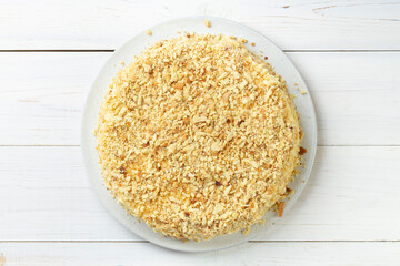 Homemade honey cake with sour cream on a white wooden table. Space for text.