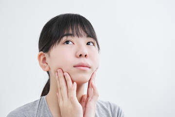 顎をマッサージする日本人女子中学生