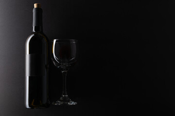 Elegant bottle and glass black background. Advertising and promotion concept. Mock up. Flat lay. Space for text.