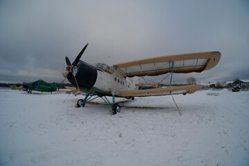 An old biplane is in the airplane parking lot