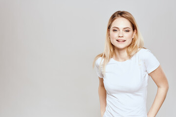 Cute blonde white t-shirt gesture with hands lifestyle light background 