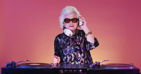 Cheerful and cool stylish Caucasian retro female DJ on retirement spinning record on disco mixer...
