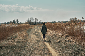 The girl is walking along a country road. Fall. Camping. Minimalism.