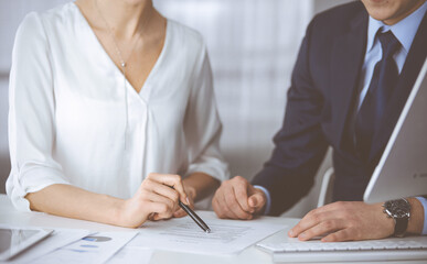 Unknown businessman and woman discussing contract in office. closeup.Business people or lawyers working together at meeting. Teamwork and partnership