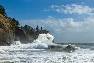 Cape Disappointment Lighthouse with a crashing wave.