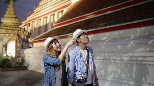 Traveler Asian couple travel in temple Bangkok, Thailand, sweet couple  spending holiday trip in sunset. Lifestyle couple travel in city concept.Young fun happy Asian tourist backpacker travel.