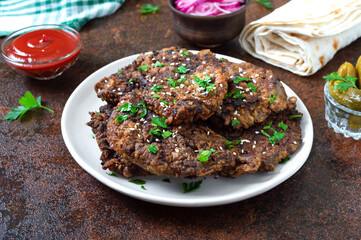 Fried liver pieces with tomato sauce, pickled onions and cucumbers. Delicious healthy dish.