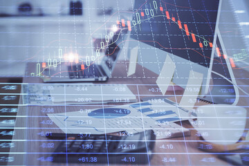Financial graph colorful drawing and table with computer on background. Multi exposure. Concept of international markets.