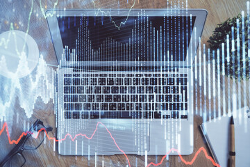 Double exposure of chart and financial info and work space with computer background. Concept of international online trading.