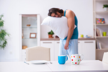 Young man waking up at home