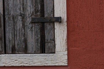 Detail of old wooden window. Vintage object with particular on the object iron closing hinge.