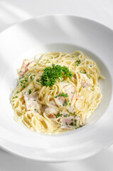 spaghetti carbonara pasta dish on white table background