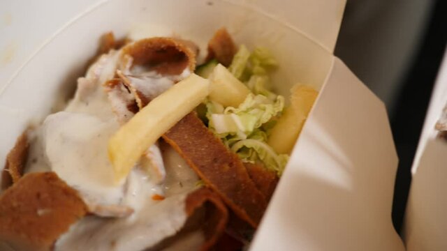 Opened boxes of food delivery in takeaway paper boxes a doner kebab meat dish with sauce