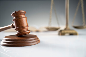 Law and justice concept. Gavel, legal code and scale on the off-white background.