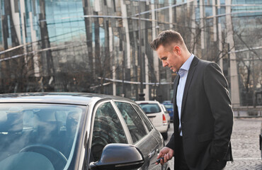 businessman opens the door of his car