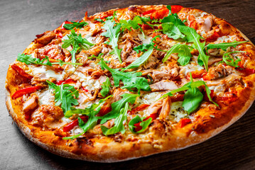 Pizza with Mozzarella cheese, salmon fish, tomato sauce, pepper. Italian pizza on wooden table background