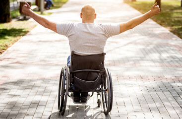Handicapped man in wheelchair walk at the park alley