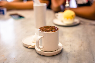 Blurred background view Of the beverage menu with chocolate powder sprinkled on top, placed in a white glass and placed for customer service