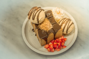 Blurred background view Of the dessert menu (Honey Toast) that contains ice cream, whipped cream, sour fruit like strawberries to be decorated and served to the customer.