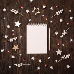 Empty white notebook,  Christmas decorations, snowflakes on dark wooden background.