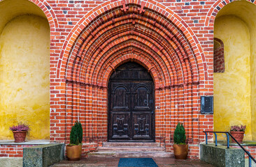 Fototapeta na wymiar Extremely vaulted entrance door to an old brick church in Sweden