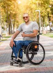 Handicapped man in wheelchair walk at the park alley