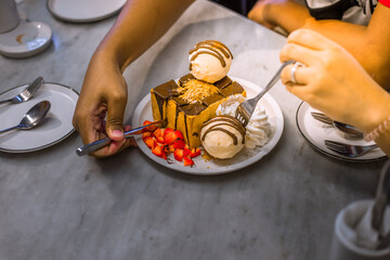 Blurred background view Of the dessert menu (Honey Toast) that contains ice cream, whipped cream, sour fruit like strawberries to be decorated and served to the customer.