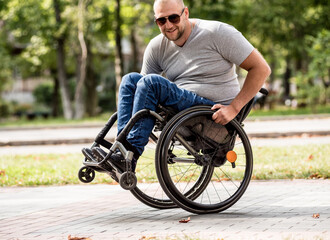 Handicapped man in wheelchair walk at the park alley