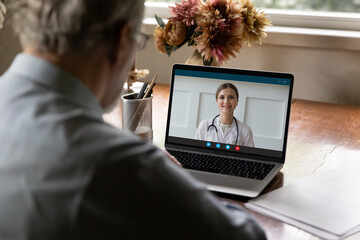 Back view retired old man holding video call conversation, consulting with young female doctor...