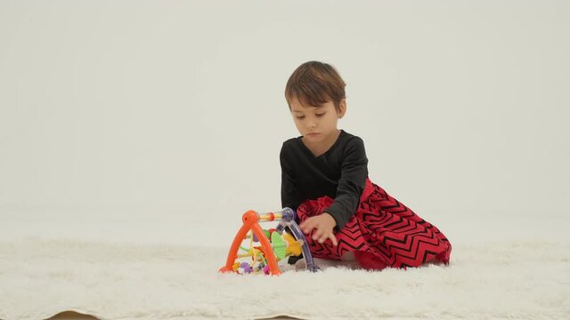 Two little girls playing toys in a white room. Slow motion