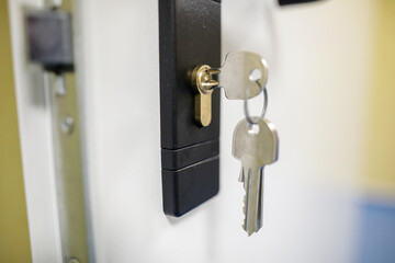 Shallow depth of field (selective focus) image with metal keys into a door lock.