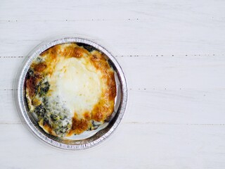 Mozzarella cheese melt on spinach baked serve in foiled cup