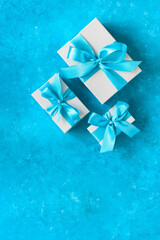 Gift boxes with blue ribbon. Turquoise blue grunge background. Top view, flat lay, copy space.